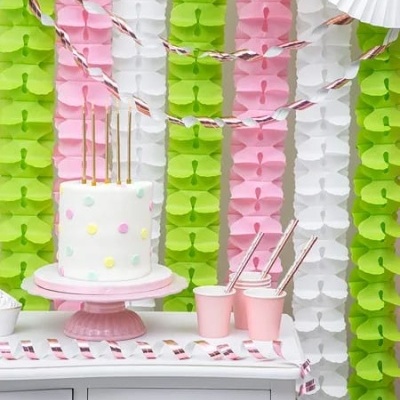 Bolo decorado com bolinhas coloridas e decoração de papel colorida ao fundo