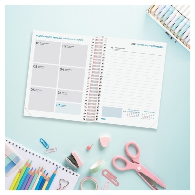Planner semanal aberto com lápis de cor e material de escritório rosa e azul claro
