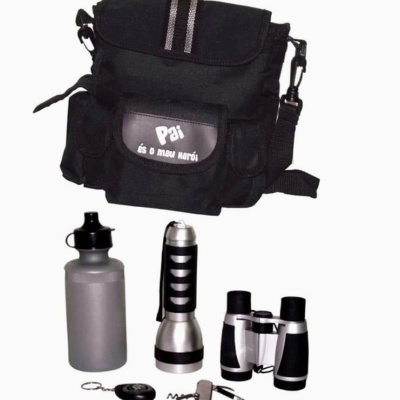 Conjunto de mochila preta com texto, garrafa cinza, lanterna metálica, binóculos e chaveiro