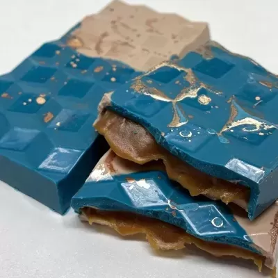 Pedaços de chocolate azul com recheio castanho e decoração dourada