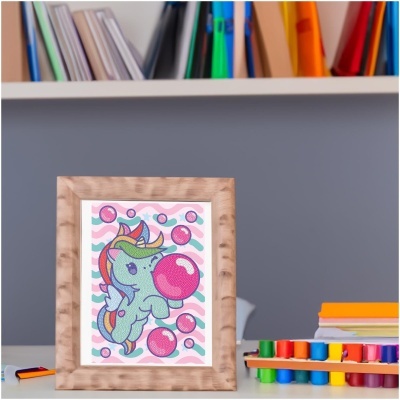 quadro de unicórnio colorido com bolhas numa moldura de madeira sobre mesa com livros e tintas