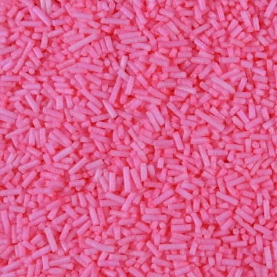 Pequenos confeitos cilíndricos cor-de-rosa para decoração de doces