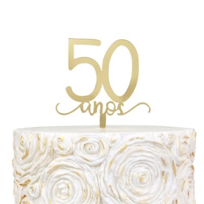 Bolo branco decorado com espirais douradas e topper dourado com texto 50 anos