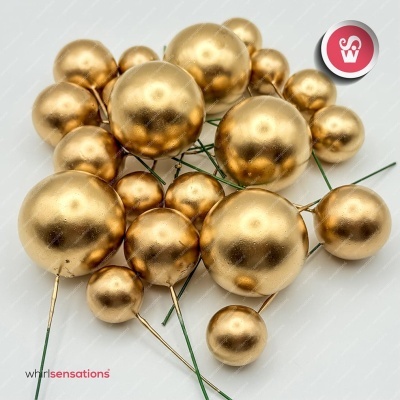 Esferas decorativas douradas com arames verdes sobre fundo branco