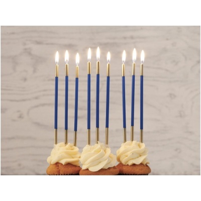 Cupcakes com velas azuis finas acesas e cobertura branca cremosa.