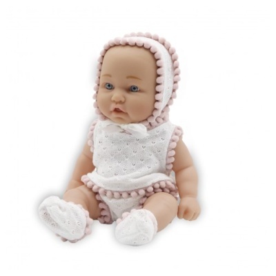 Boneca de bebé vestida com conjunto branco de malha com pompons cor-de-rosa sentada