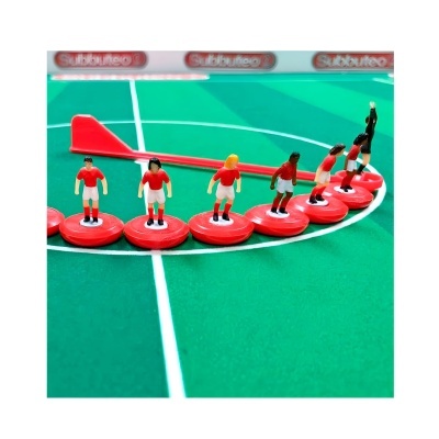 Jogo de futebol de mesa com miniaturas de jogadores em bases vermelhas e campo verde