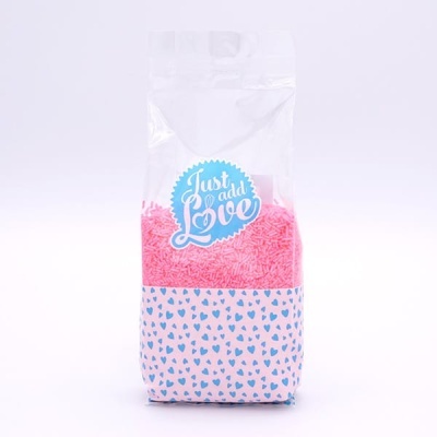 Pacote de confeitos rosas com padrão de corações azuis e etiqueta 