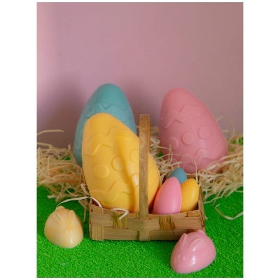 Ovos coloridos em cesto de verga com palha decorativa