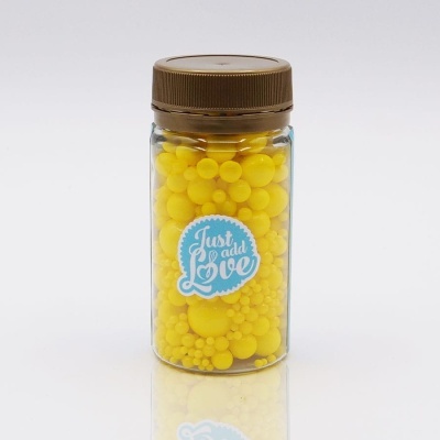 Frasco com pequenas bolas amarelas e etiqueta 'Just add Love'