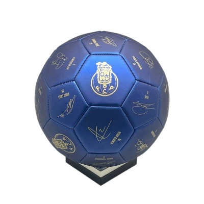 Bola de futebol azul com assinaturas douradas do FC Porto num suporte