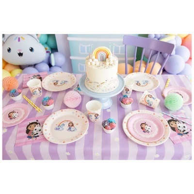 Mesa de festa decorada com toalha lilás, pratos, copos, cupcakes coloridos e bolo com arco-íris.