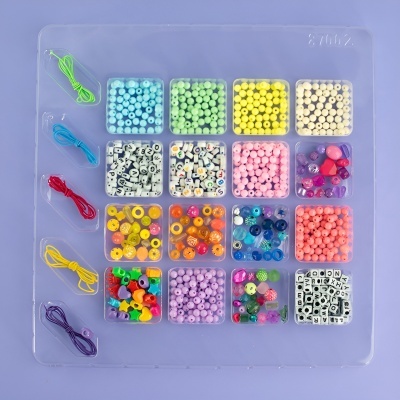 Conjunto de contas para bijuteria organizadas em compartimentos transparentes com várias cores e formatos.