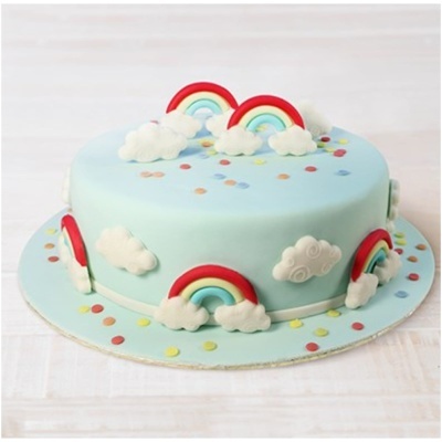 Bolo azul claro com decoração de arcos-íris e nuvens em relevo e confetes coloridos