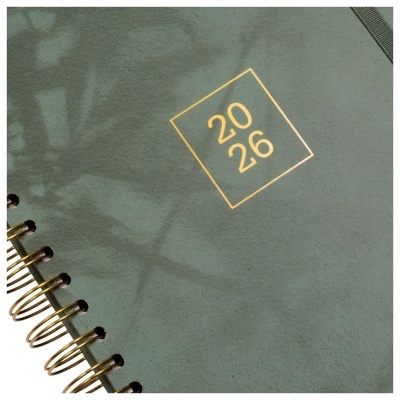 Caderno verde com espiral dourado e texto 2026 na capa