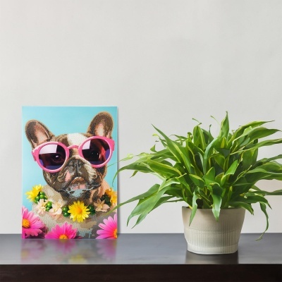Quadro de bulldog com óculos cor-de-rosa e flores ao lado de planta verde em vaso branco