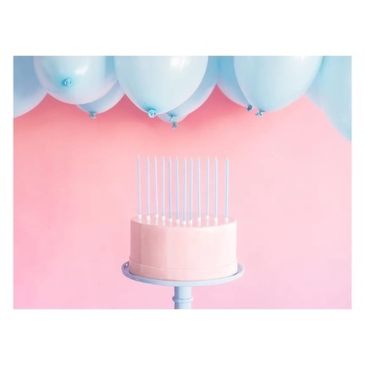Bolo rosa liso com velas azuis e balões brancos em fundo rosa