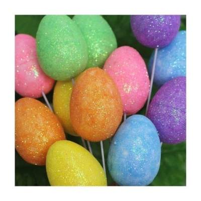 Conjunto de ovos decorativos coloridos com brilho em hastes finas sobre fundo verde