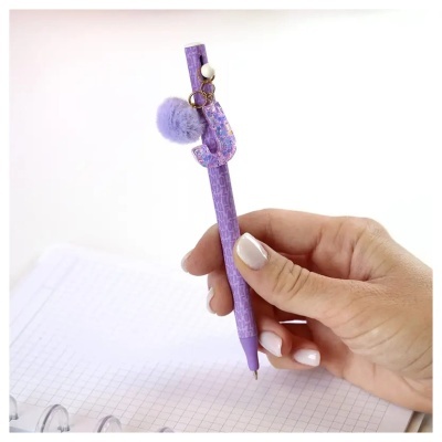 Caneta roxa com chaveiro de pompom e letra J holográfica
