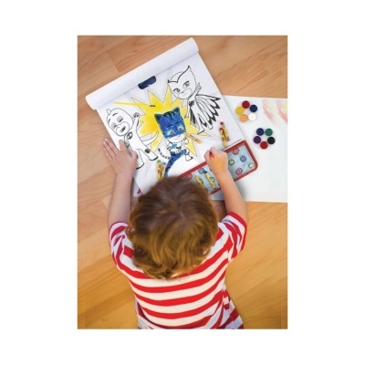 Criança pinta desenhos de heróis em folha grande com aquarelas coloridas.