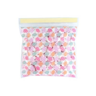 Saco transparente com mini corações de tecido coloridos com bolinhas.