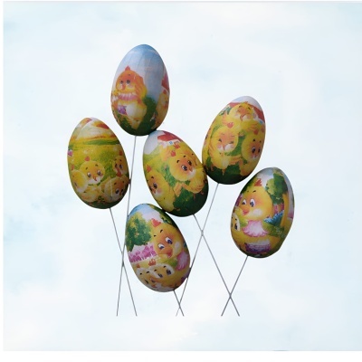 Ovos de Páscoa decorativos com pintainhos, em hastes metálicas contra o céu