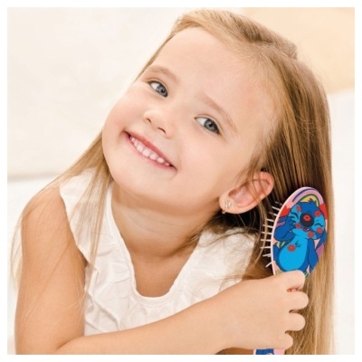 Menina loira a escovar o cabelo com escova colorida