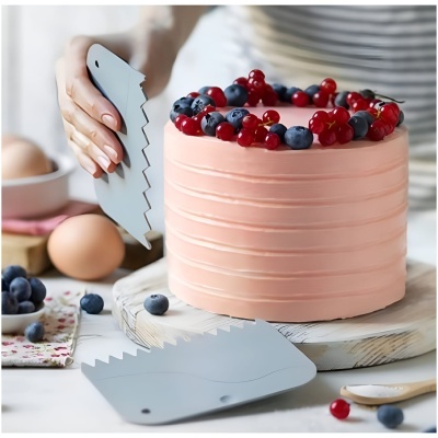 Raspador cinzento a alisar cobertura rosa de bolo decorado com mirtilos e groselhas vermelhas.