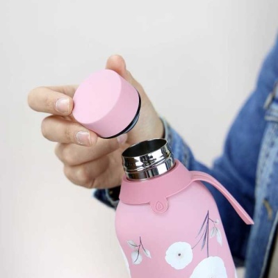 Garrafa térmica rosa com estampas florais e tampa rosa removida