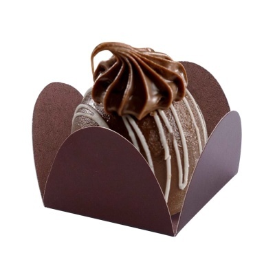 Doce de chocolate redondo com creme e decoração branca numa base de papel castanho