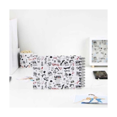 Álbum de fotos com capa branca decorada com desenhos e texto em preto e vermelho, espiral preto