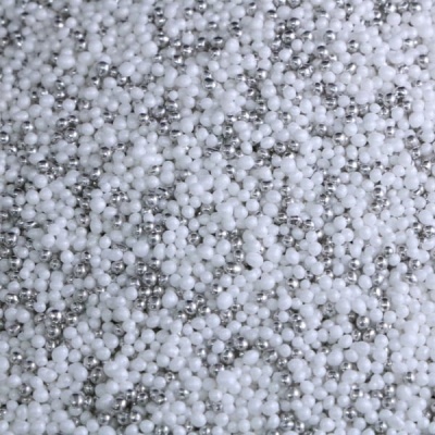 Pequenas pérolas brancas e prateadas misturadas com superfícies lisas