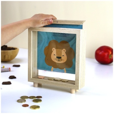 Cofre de madeira clara com leão sorridente e moedas