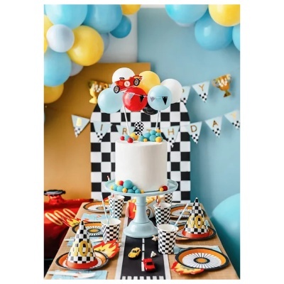 Mesa de festa de aniversário decorada com tema de corrida, bolo, balões e acessórios em padrão xadrez.