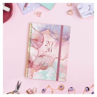 Agenda 2026 com design artístico em tons pastel, rosa, azul e dourado com elástico na capa