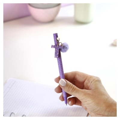 Caneta roxa decorada com pingentes de cruz, pérola e bola felpuda