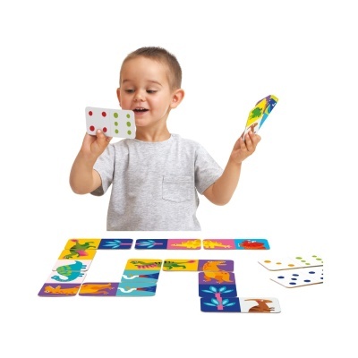 Criança a jogar domino com cartas coloridas de dinossauros e pontos coloridos