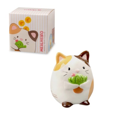 Mealheiro em forma de gato branco com manchas castanhas e amarelas a segurar um cacto verde com flores cor-de-rosa, ao lado da sua caixa decorada.