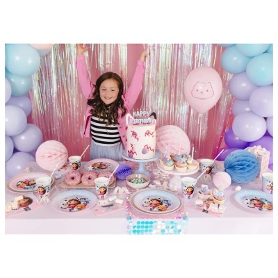 Mesa decorada para festa infantil com bolo, cupcakes, balões e menina sorridente