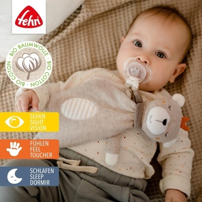 Bebé com chupeta e peluche em manta bege