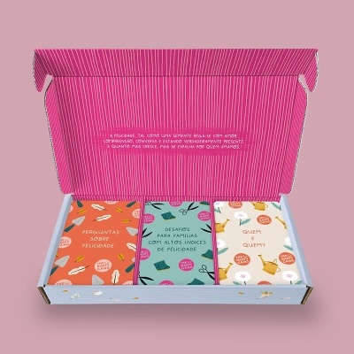 Caixa com três baralhos de cartas coloridas sobre felicidade