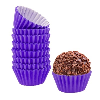 Forminhas roxas empilhadas e um brigadeiro com chocolate em forminha roxa