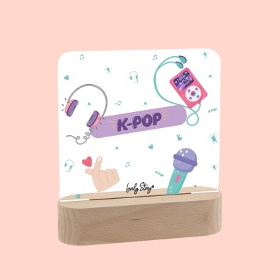 Objeto decorativo K-POP com base de madeira e placa transparente ilustrada.