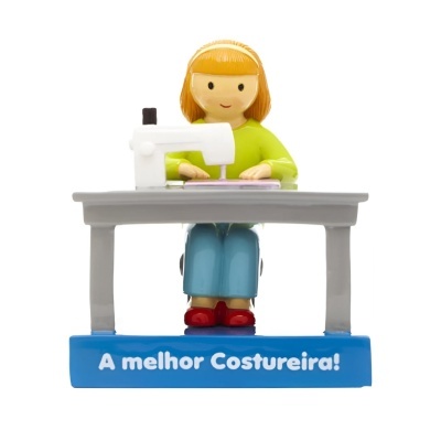 Figura decorativa de mulher a costurar numa máquina de costura