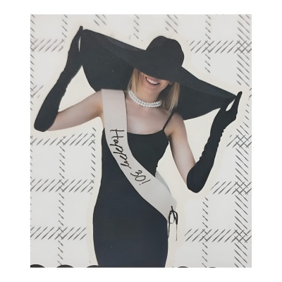 Mulher com vestido preto, luvas, chapéu largo, colar de pérolas e faixa 'Happy 30!'