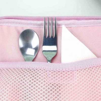 Garfo e colher em bolso de tecido rosa com guardanapo branco