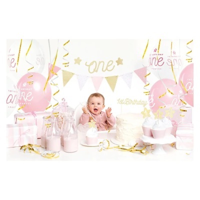 Festa de aniversário com decoração rosa, branco e dourado e criança ao centro