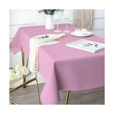 Toalha de mesa rosa com acessórios de mesa brancos e rosa em ambiente moderno