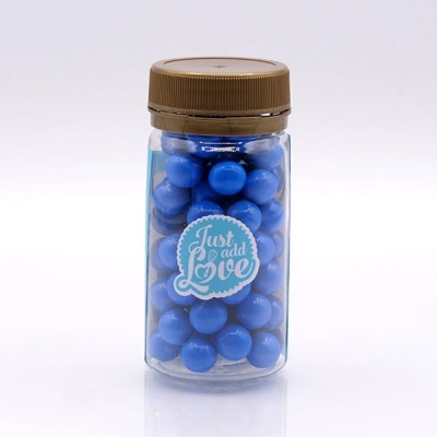 Frasco transparente com bolas azuis e etiqueta 'Just add Love'