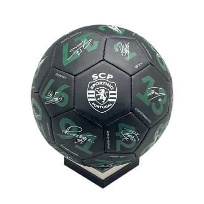 Bola de futebol preta com símbolo do Sporting e assinaturas em verde e branco